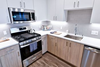 a kitchen with white cabinets and stainless steel appliances